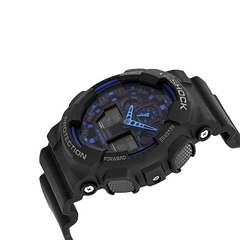 Imagem em close-up de um relógio de pulso G-Shock de resina preta com design robusto. O relógio possui um mostrador analógico azul com ponteiros brancos e azuis, inserido em uma tela digital. O aro é marcado com as palavras ‘Shock Resist’ na parte superior e ‘Protection’ na parte inferior, enquanto o lado direito tem dois botões rotulados como ‘Adjust’ e ‘Forward’. O design geral sugere durabilidade e funcionalidade, adequado para uso ativo.