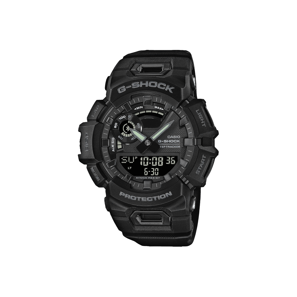 Relógio Casio G-Shock de resina preta com display digital-analógico. O design é robusto, com vários botões e detalhes texturizados nas laterais. A tela digital mostra a hora 10:08:36 e a data 6-30, indicando 30 de junho. Os ponteiros do relógio analógico estão próximos das marcas de 10 e 2 horas. A palavra ‘PROTECTION’ está destacada na parte inferior do mostrador, enfatizando sua construção durável
