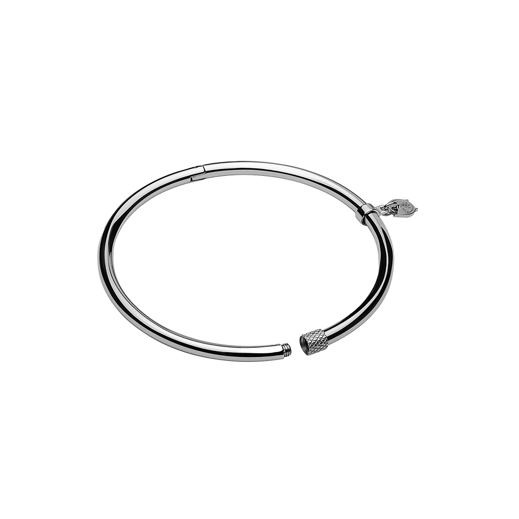 Uma pulseira circular de aço com acabamento metálico elegante. O design é simples, mas sofisticado, com um mecanismo de fecho para abrir e fechar. Nas extremidades da pulseira, há elementos decorativos que parecem ser tampas estilizadas, adicionando um toque estético à peça minimalista.