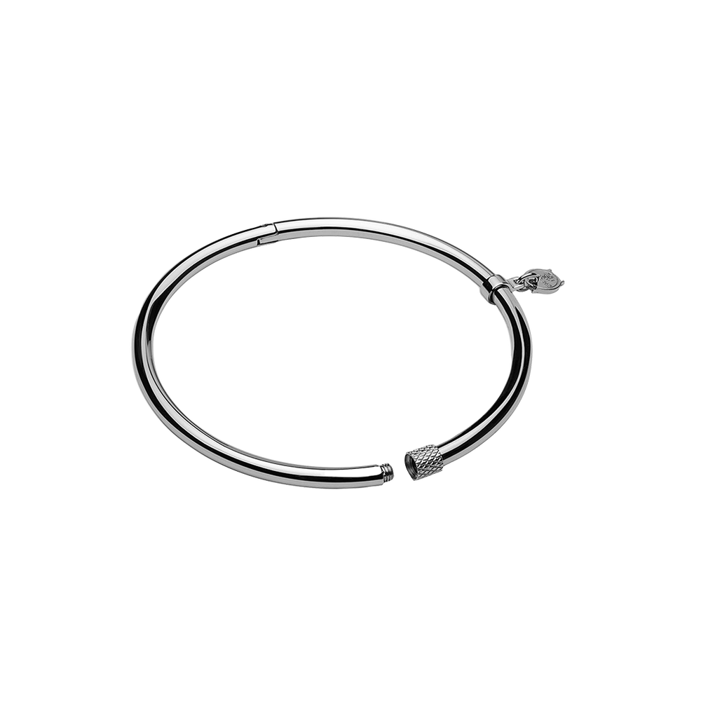 Uma pulseira circular de aço com acabamento metálico elegante. O design é simples, mas sofisticado, com um mecanismo de fecho para abrir e fechar. Nas extremidades da pulseira, há elementos decorativos que parecem ser tampas estilizadas, adicionando um toque estético à peça minimalista