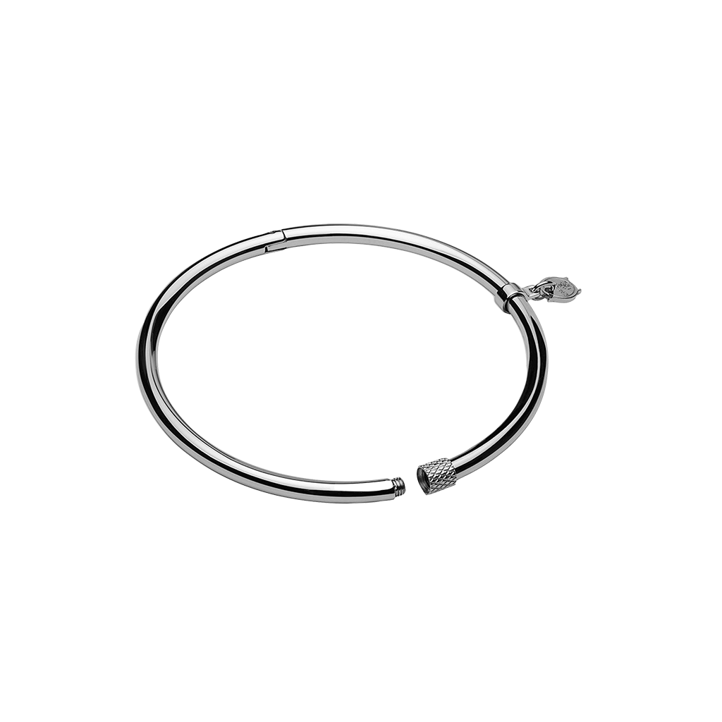 Uma pulseira circular de aço com acabamento metálico elegante. O design é simples, mas sofisticado, com um mecanismo de fecho para abrir e fechar. Nas extremidades da pulseira, há elementos decorativos que parecem ser tampas estilizadas, adicionando um toque estético à peça minimalista