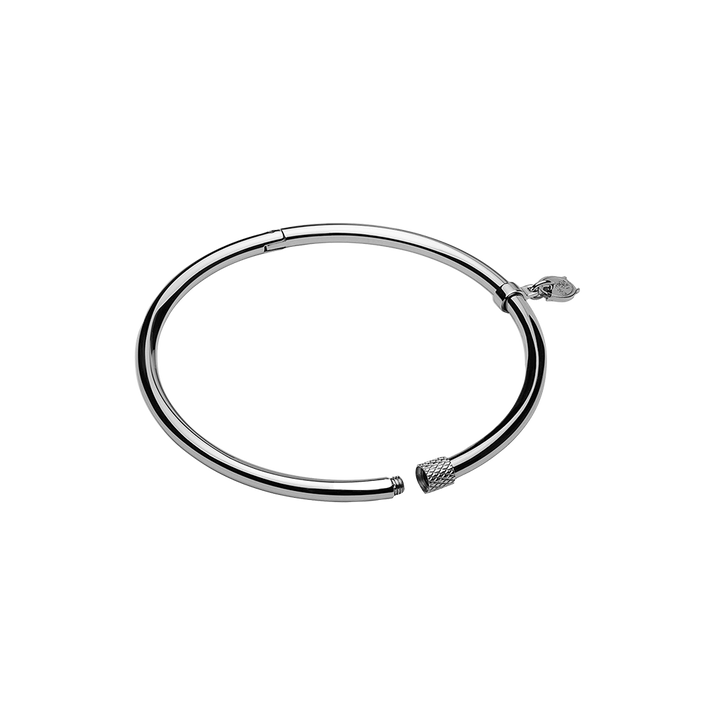 Uma pulseira circular de aço com acabamento metálico elegante. O design é simples, mas sofisticado, com um mecanismo de fecho para abrir e fechar. Nas extremidades da pulseira, há elementos decorativos que parecem ser tampas estilizadas, adicionando um toque estético à peça minimalista