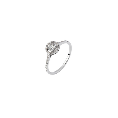 Um anel de ouro branco de 18 quilates (18kt) com um diamante central proeminente, cortado em formato redondo e fixado em uma configuração elevada de quatro garras. A banda do anel é adornada com diamantes menores, dispostos em pavé, que se estendem pela metade de sua circunferência, adicionando brilho e elegância ao design