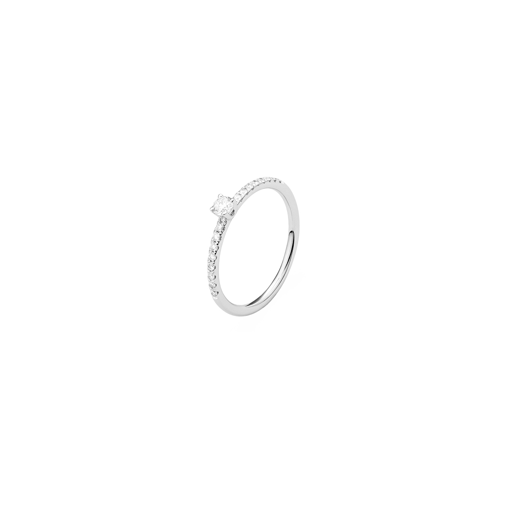 Um anel de ouro branco com uma banda esbelta, apresentando pequenos diamantes incrustados ao longo da metade superior. No centro, há um diamante quadrado maior e proeminentemente exibido que se destaca contra a configuração delicada. 