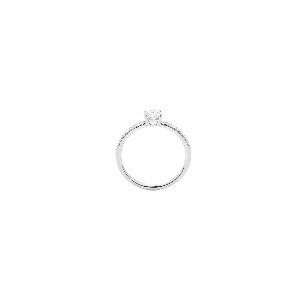 imagem lateral de anel de ouro branco com uma banda fina, adornado com pequenos diamantes que circundam metade da banda. O anel apresenta um diamante solitário proeminente montado no topo em uma configuração de garra.